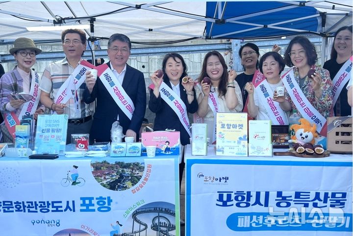 [포항=뉴시스] 송종욱 기자 = 5일 경북 울릉군 저동항 일원에서 '제22회 울릉도 오징어 축제'가 열린 가운데 자매 도시 포항시가 홍보 부스를 운영하며 포항 지역 주요 관광지, 축제, 농특산물을 홍보했다. 사진은 포항 홍보관에서 장상길(왼쪽에서 세번 째) 부시장과 직원, 재포울릉향우회원들이 포항의 농특산물을 홍보하며 기념 촬영을 하고 있다. (사진=포항시 제공) 2024.08.06. photo@newsis.com 