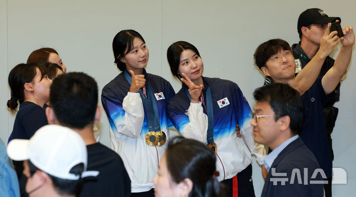 [인천공항=뉴시스] 고범준 기자 = 2024 파리 올림픽 양궁 전 종목에서 금메달을 획득한 대한민국 양궁 대표팀 임시현과 남수현이 6일 오전 인천국제공항 제2여객터미널을 통해 귀국해 관계자와 기념촬영을 하고 있다. 2024.08.06. bjko@newsis.com