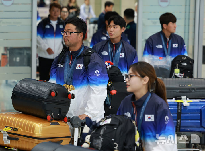 [인천공항=뉴시스] 고범준 기자 = 2024 파리 올림픽 양궁 전 종목에서 금메달을 획득한 대한민국 양궁 대표팀 김우진(왼쪽부터), 이우석, 김제덕이 6일 오전 인천국제공항 제2여객터미널을 통해 귀국하고 있다. 2024.08.06. bjko@newsis.com