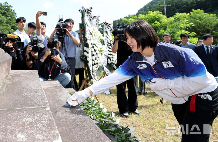 [대구=뉴시스] 이무열 기자 = 2024 파리 올림픽 유도 여자 57㎏급 은메달과 혼성단체 동메달을 획득한 허미미(21·경북체육회)가 6일 오전 대구 군위군 삼국유사면 화수리에 조성된 독립운동가 현 조부 허석 의사 기적비에 메달을 올려두고 있다. 2024.08.06. lmy@newsis.com