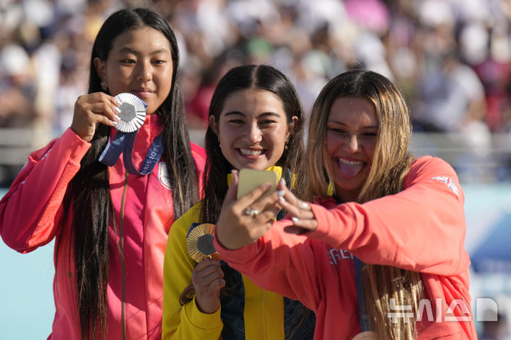 [파리=AP/뉴시스] 6일(현지시각) 프랑스 파리의 라 콩코르드 광장 경기장에서 열린 '2024 파리올림픽' 스케이트보드 여자 파크 종목에서 금메달을 차지한 아리사 트루(가운데)가 은메달리스트 코코나 히라키(왼쪽), 동메달리스트 스카이 브라운(오른쪽)과 함께 기념사진을 찍고 있다. 2024.08.06.