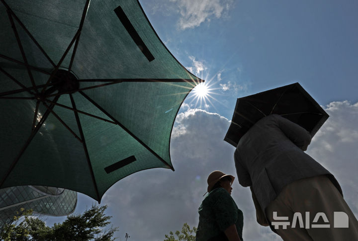 [서울=뉴시스] 김금보 기자 = 절기상 입추인 7일 오후 서울 중구 세종대로에서 시민들이 폭염을 피해 양산을 쓰고 이동하고 있는 모습. 2024.08.07. kgb@newsis.com