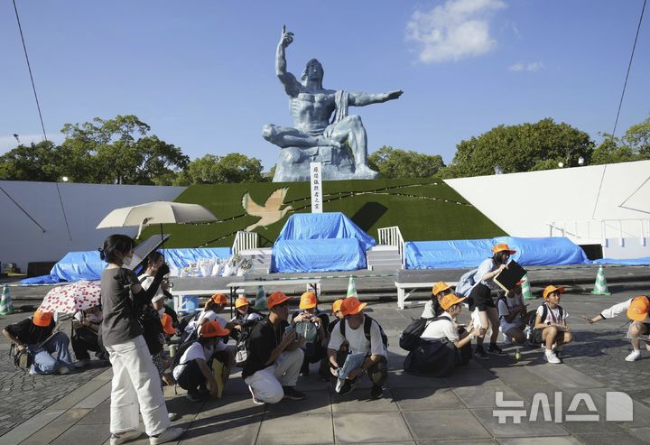 [나가사키=AP/뉴시스] 8일 일본 서부 나가사키의 평화공원을 찾은 관람객들이 지진 경보 발령에 몸을 웅크려 대비하고 있다. 이날 오후 미야자키현 앞바다에서 규모 6.9의 지진이 발생해 미야자키현과 고치현에 쓰나미 주의보가 내려졌다. 2024.08.08.
