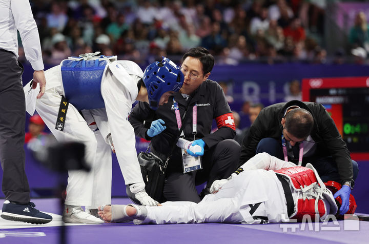 [파리=뉴시스] 김진아 기자 = 박태준이 7일(현지시각) 프랑스 파리 그랑 팔레에서 열린 2024 파리 올림픽 태권도 남자 58kg급 결승전에서 경기 도중 부상을 당한 상대 선수 아제르바이잔 가심 마고메도프를 걱정스러운 표정으로 바라보고 있다. 2024.08.08. bluesoda@newsis.com