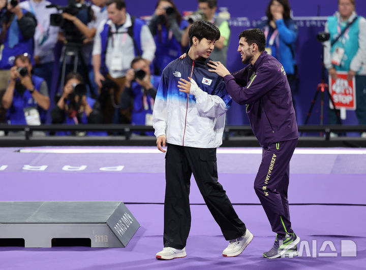 [파리=뉴시스] 김진아 기자 = 박태준이 7일(현지시각) 프랑스 파리 그랑 팔레에서 열린 2024 파리 올림픽 태권도 남자 58kg급 시상식에서 결승 경기 도중 부상을 당한 아제르바이잔 가심 마고메도프를 부축하며 시상대로 향하고 있다. 2024.08.08. bluesoda@newsis.com