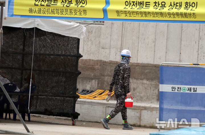 [서울=뉴시스] 김명년 기자 = 서울 성북구 장위4구역 주택정비사업 건설현장에서 근로자가 음료를 들고 이동하고 있다.(공동취재) 2024.08.08. kmn@newsis.com