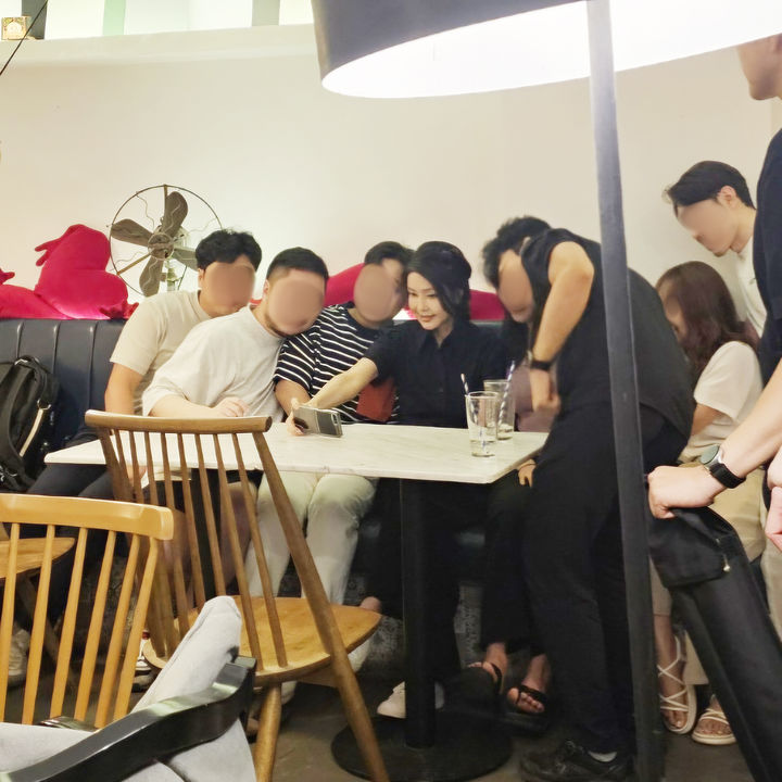 [서울=뉴시스] 조수정 기자 = 여름 휴가중인 윤석열 대통령 부인 김건희 여사가 6일 부산 광안리 해변 카페에서 지역청년들의 요청에 휴대전화로 함께 사진을 찍고 있다. (사진=대통령실 제공) 2024.08.08. photo@newsis.com *재판매 및 DB 금지