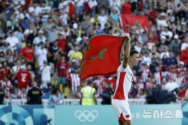 [낭트=AP/뉴시스] 모로코 남자 축구 국가대표 빌랄 엘 카누스가 9일(한국시각)프랑스 낭트의 스타드 드 라 보주아르에서 열린 '2024 파리올림픽' 남자 축구 동메달 결정전에서 승리한 뒤 국기를 들고 세리머니를 펼치고 있다. 2024.08.09.