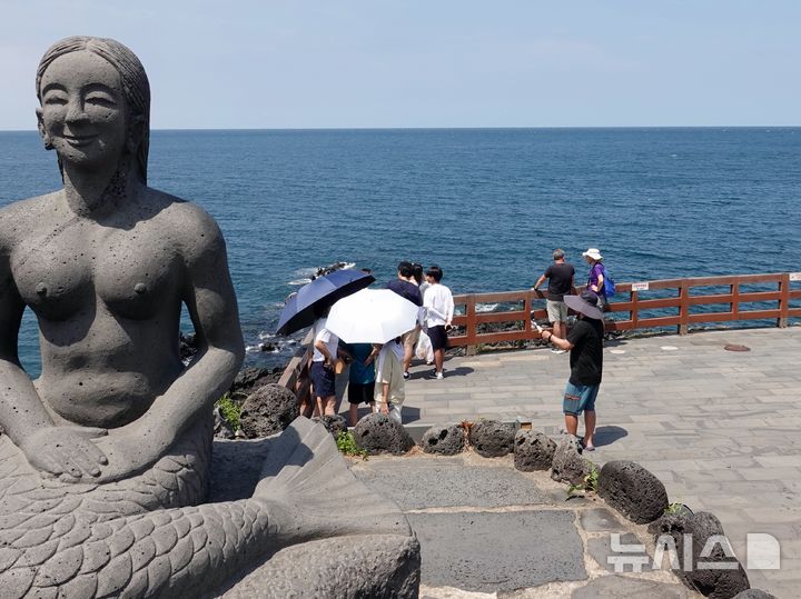 [제주=뉴시스] 오영재 기자 = 폭염경보가 내려진 11일 오후 제주시 용두암에서 양산을 쓴 관광객들이 즐거운 시간을 보내고 있다. 2024.08.11. oyj4343@newsis.com