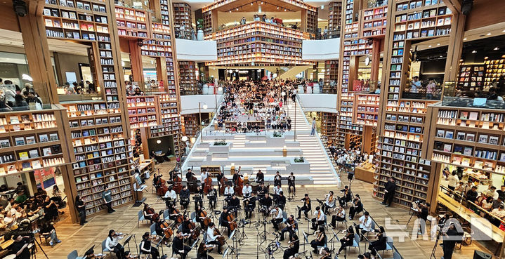 [수원=뉴시스] 김종택 기자 = 한낮 체감온도가 35도 안팎으로 오르는 등 연일 무더위가 이어지고 있는 11일 경기도 수원시 장안구 '스타필드 수원' 별마당도서관을 찾은 시민들이 콘서트를 관람하며 더위를 피하고 있다. 2024.08.11. jtk@newsis.com