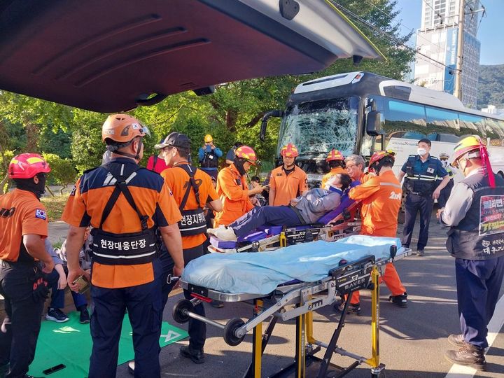 [거제=뉴시스] 12일 오전 7시3분께 거제시 아주동 아주푸르지오 아파트 앞 편도 4차선에서 회사 통근버스 2대가 추돌해 운전기사 등 탑승객 2명이 중상을 입었다. 사진은 거제소방서 구조대원들이 부상자를 인근 병원으로 이송하고 있다. (사진=경남소방본부 제공) 2024.08.12. photo@newsis.com *재판매 및 DB 금지