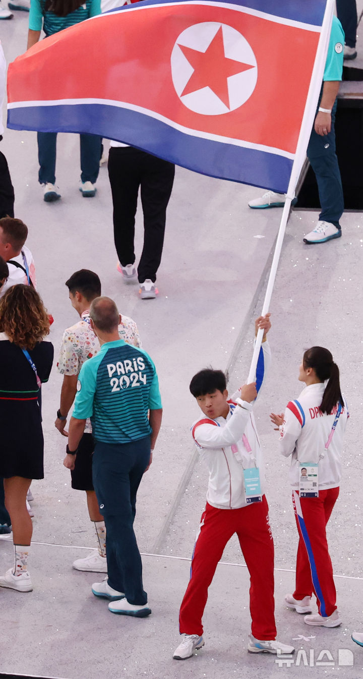 [생드니=뉴시스] 최동준 기자 = 11일(현지시각) 프랑스 생드니 스타드 드 프랑스에서 열린 2024 파리 올림픽 폐회식에서 북한 선수단이 인공기를 들고 입장하고 있다. (공동취재) 2024.08.12. photo@newsis.com