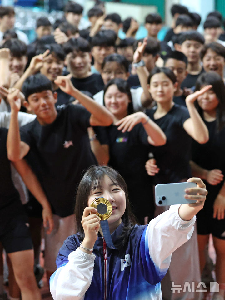 [대구=뉴시스] 이무열 기자 = 2024 파리 올림픽 한국 사격 국가대표 반효진이 12일 오전 대구 북구 대구체육고등학교 필승관에서 열린 ‘파리올림픽 신기록 수립 및 100번째 금메달 획득 기념 환영식’에서 재학생들과 셀카를 찍고 있다. 2024.08.12. lmy@newsis.com