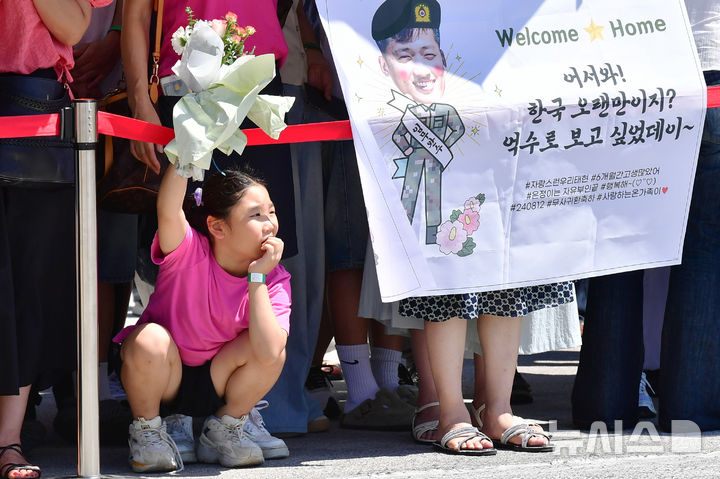 [진해=뉴시스] 차용현 기자 = 12일 오전 경남 창원시 진해구 진해군항에서 청해부대 42진 파병 복귀 환영 행사가 개최되고 있는 가운데 꽃다발을 든 한 어린이가 복귀한 대원을 기다리고 있다. 2024.08.12.con@newsis.com