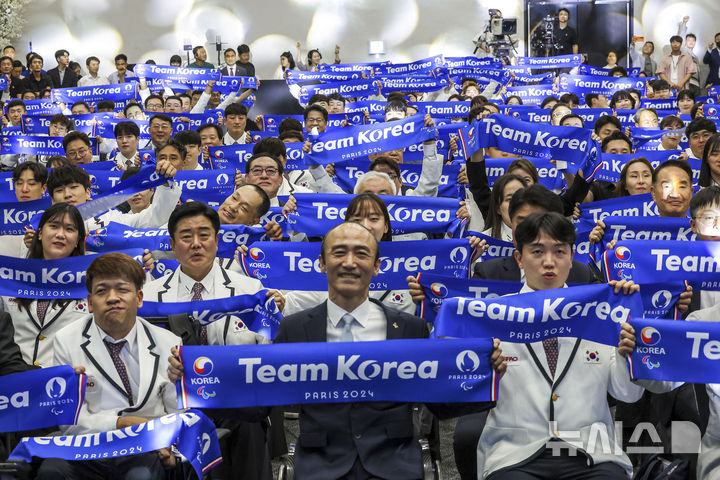 [서울=뉴시스] 정병혁 기자 = 12일 서울 송파구 올림픽파크텔에서 열린 2024 파리 패럴림픽대회 대한민국 선수단 결단식에서 선수단이 팀 코리아라고 적힌 머플러를 들고 기념촬영을 하고 있다. 2024.08.12. jhope@newsis.com