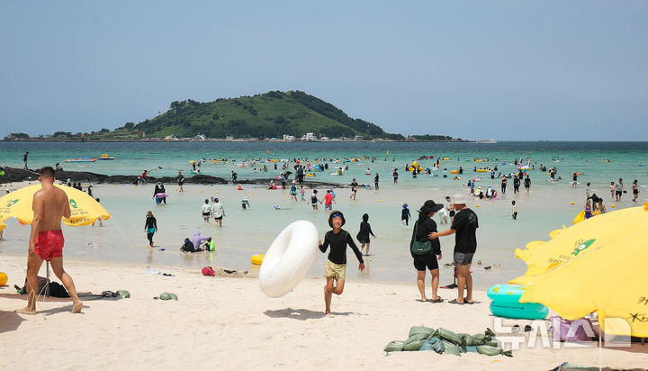 [제주=뉴시스] 우장호 기자 =  제주시 한림읍 협재해수욕장을 찾은 관광객들이 시원한 바닷물에 몸을 담그며 한낮 더위를 식히고 있다. 2024.08.13. woo1223@newsis.com