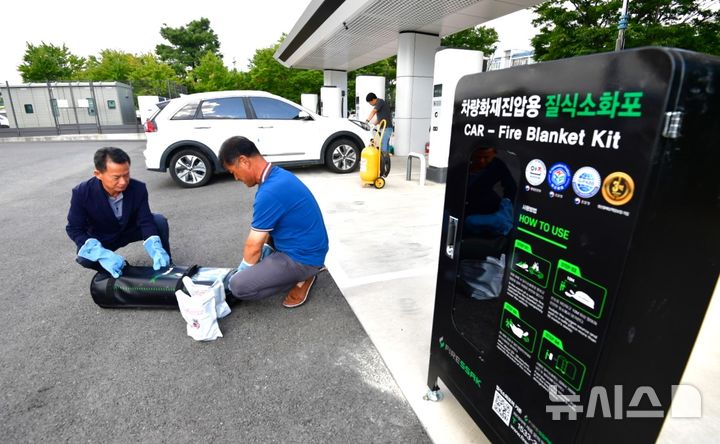 [포항=뉴시스] 송종욱 기자 = 지난 13일 경북 포항시 남구 포항야구장 앞 전기차 충전소에서 최근 전국에서 발생하는 전기차 화재와 관련해 포항시 관계자 등이 화재 진압 시설인 '질식 소화포' 시설을 점검하고 있다. (사진=포항시 제공) 2024.08.14. photo@newsis.com