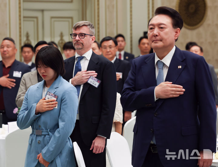 [서울=뉴시스] 최진석 기자 =  윤석열 대통령이 14일 청와대 영빈관에서 열린 독립유공자 후손 초청 오찬에서 독립유공자 후손 등을 비롯한 참석자들과 국기에 경례를 하고 있다. 왼쪽은 독립운동가 허석 의사의 후손인 2024 파리올림픽 유도 개인전 은메달, 혼성 단체전 동메달리스트 허미미. (대통령실통신사진기자단) 2024.08.14. myjs@newsis.com