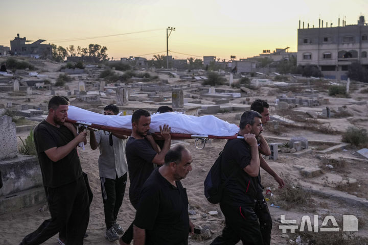 Palestinian mourners carry their loved one for burial at the cemetery in Deir al-Balah, Gaza Strip, Friday, Aug. 9, 2024. (AP Photo/Abdel Kareem Hana)