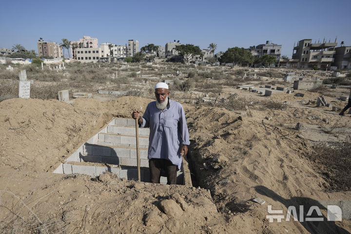 Palestinian grave digger Sa'di Baraka pauses while digging new graves in a cemetery in Deir al-Balah, Gaza Strip, Friday, Aug. 2, 2024, making room for more killed in the 10-month-old war. "We bury martyrs," Baraka said. "Sometimes we make graves on top of graves." (AP Photo/Abdel Kareem Hana)