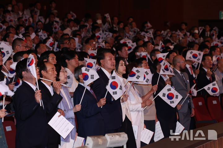 [서울=뉴시스] 조수정 기자 = 윤석열 대통령과 부인 김건희 여사를 비롯한 참석자들이 15일 서울 종로구 세종문화회관에서 열린 제79주년 광복절 경축식에서 태극기를 흔들며  광복절 노래를 제창 하고 있다. 2024.08.15. chocrystal@newsis.com