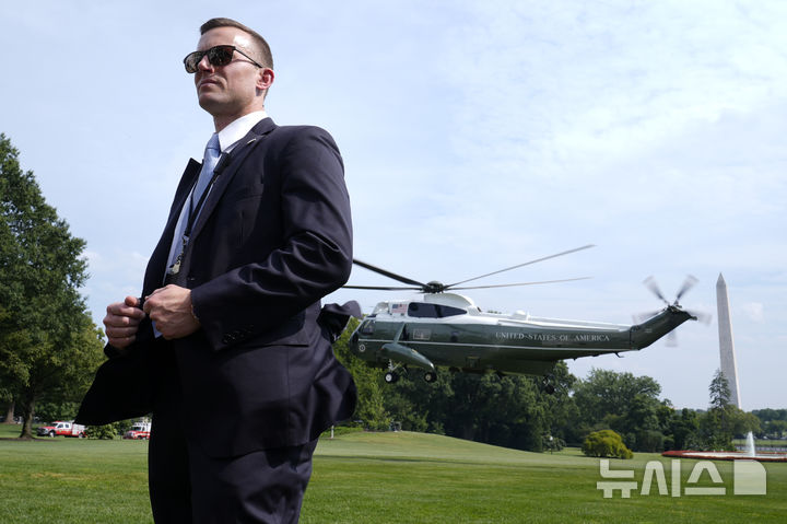 [워싱턴DC=AP/뉴시스]미국 백악관 인근에서 9일(현지 시간) 오전 무장한 남성이 비밀경호국과 대치 끝에 총에 맞아 병원으로 이송됐다. 사진은 지난해 8월 16일 당시 대통령이던 조 바이든이 탑승한 대통령 전용기 마린원이 이륙하고 있는 가운데 비밀경호국 요원이 경호하고 있는 모습. 2025.03.09.