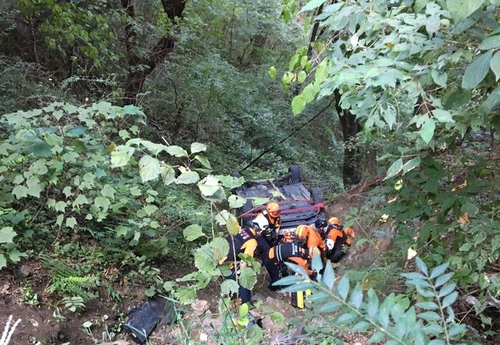 [괴산=뉴시스] 이도근 기자= 18일 오후 2시46분께 충북 괴산군 청천면 한 야산에서 SUV차량이 임도 20m 아래로 추락하는 사고가 발생하자 출동한 소방대원들이 구조를 하고 있다. (사진=충북도소방본부 제공) 2024.8.18. photo@newsis.com *재판매 및 DB 금지