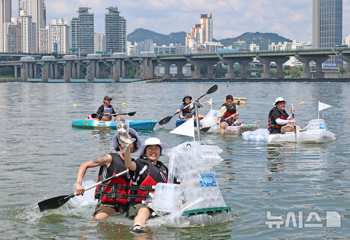 [서울=뉴시스] 김금보 기자 = 18일 오후 서울 송파구 잠실한강공원에서 열린 나만의 한강호 경주대회에서 참가자들이 페트병으로 직접 제작한 배를 타고 노를 저어 주항하고 있다. 2024.08.18. kgb@newsis.com