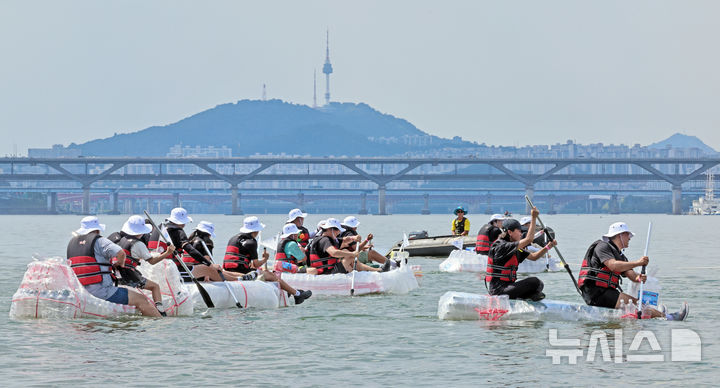 [서울=뉴시스] 김금보 기자 = 18일 오후 서울 송파구 잠실한강공원에서 열린 나만의 한강호 경주대회에서 참가자들이 페트병으로 직접 제작한 배를 타고 노를 젓고 있다. 2024.08.18. kgb@newsis.com