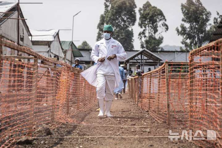A health worker walks past a mpox treatment centre in Munigi, eastern Congo, Monday, Aug. 19, 2024. Congo will receive the first vaccine doses to address its mpox outbreak next week from the United States, the country's health minister said Monday, days after the World Health Organization declared mpox outbreaks in Africa a global emergency. (AP Photo/Moses Sawasawa)
