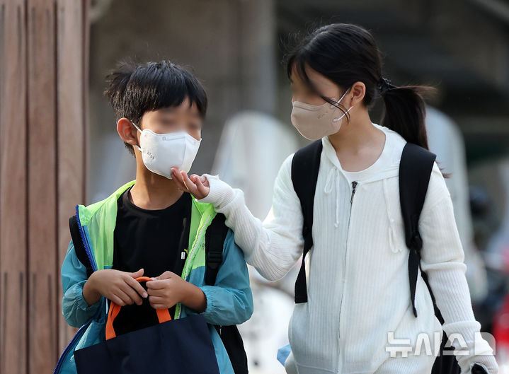 [서울=뉴시스] 김명년 기자 = 이번주 대다수 초·중·고교가 개학을 하면서 코로나 확산이 우려되고 있는 가운데 2024년 8월 20일 오전 서울시내 한 초등학교에서 등교하는 아이가 동생의 마스크를 살펴보고 있다. 2024.08.20. kmn@newsis.com