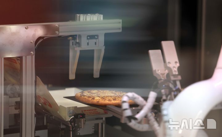 [서울=뉴시스] 조리용 로봇이 피자를 조리하고 있는 모습. (사진= 뉴시스 DB) photo@newsis.com