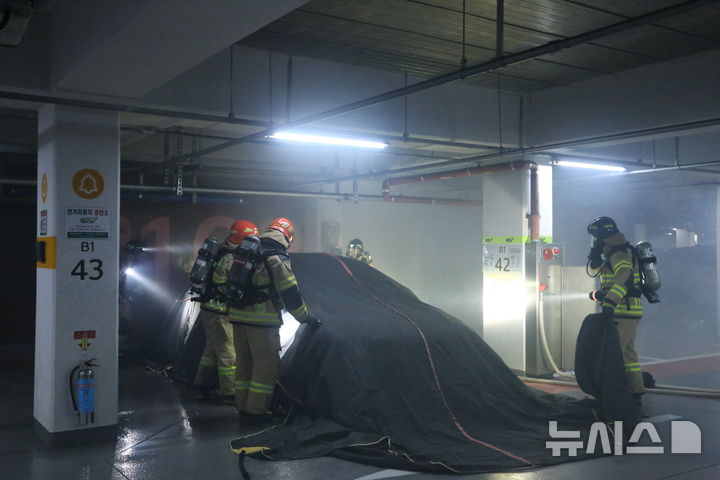 [창원=뉴시스]경남 창원소방본부 소방대원들이 지난 지난해 8월 21일 의창구 도계 휴먼시아아파트 지하주차장에서 특수전문장비를 활용한 전기차 화재진압 훈련을 하고 있다.(사진=창원소방본부 제공)2024.08.22. photo@newsis.com