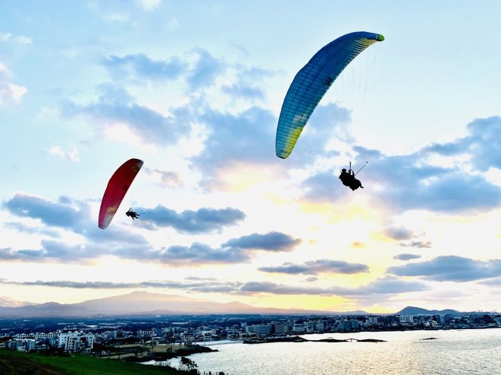 [서울=뉴시스] 패러글라이더 2인승 체험 비행을 하는 모습. 2024.08.22. (사진=제주 스카이랩 제공) photo@newsis.com *재판매 및 DB 금지