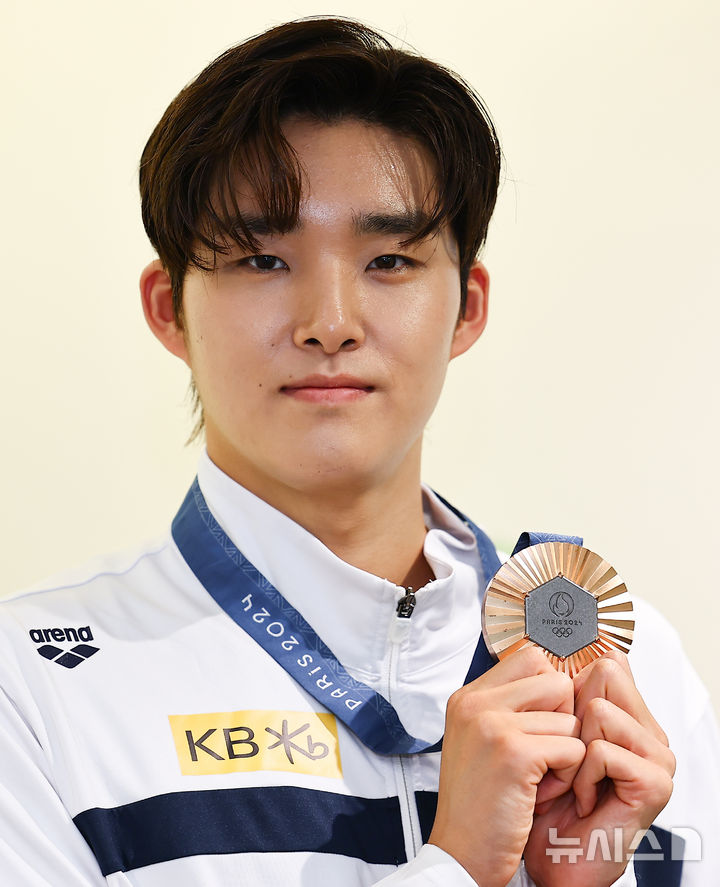 [서울=뉴시스] 김근수 기자 = 파리 올림픽 경영 남자 자유형 400m 메달리스트 김우민이 23일 서울 강남구 올댓스포츠 본사에서 뉴시스와 인터뷰 시작 전 메달을 들고 기념촬영을 하고 있다. 2024.08.23. ks@newsis.com