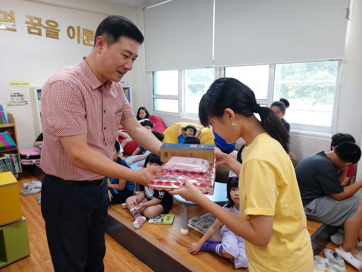 [화순=뉴시스] 전남 화순 청풍초등학교 김효관(사진 왼쪽) 교장이 전학생에게 학용품을 전달하고 있다. (사진=청풍초 제공) 2024.08.25. photo@newsis.com *재판매 및 DB 금지