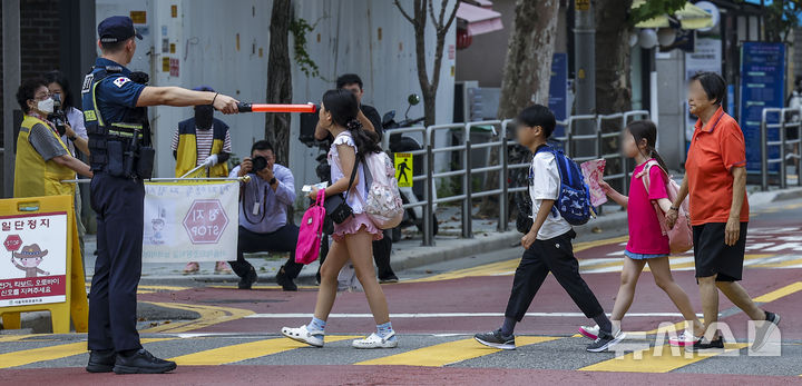 [서울=뉴시스] 정병혁 기자 = 경찰 및 서울시청 직원 및 혜화초교 녹색어머니회원들이 서울 종로구 혜화초등학교 앞에서 개학맞이 어린이 보호구역 교통법규 위반 집중단속을 하고 있다. 2024.08.26. jhope@newsis.com