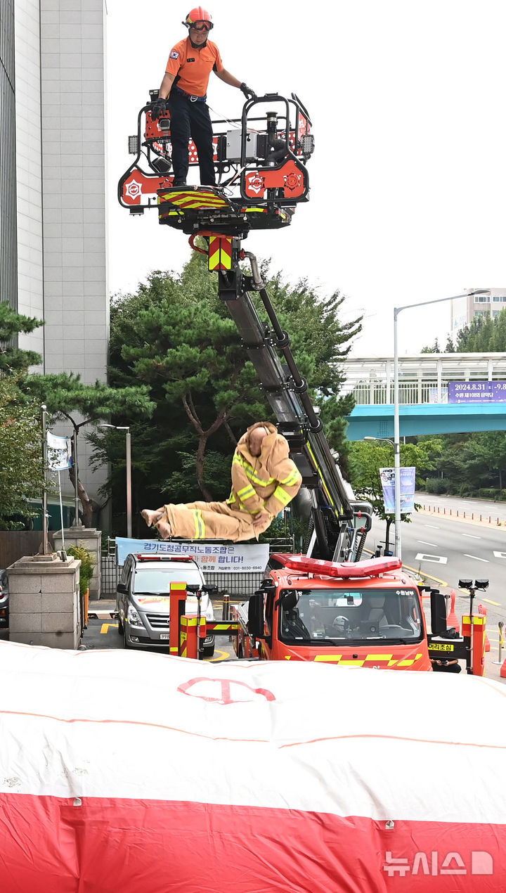 [수원=뉴시스] 김종택 기자 = 26일 경기도 수원시 권선구 수원남부119안전센터에서 소방관들이 화재현장 대응력 강화를 위한 에어매트(공기안전매트) 전개 훈련을 하고 있다. 2024.08.26. jtk@newsis.com