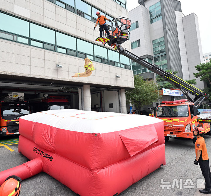 [수원=뉴시스] 김종택 기자 = 26일 경기도 수원시 권선구 수원남부119안전센터에서 소방관들이 화재현장 대응력 강화를 위한 에어매트(공기안전매트) 전개 훈련을 하고 있다. (공동취재) 2024.08.26. photo@newsis.com