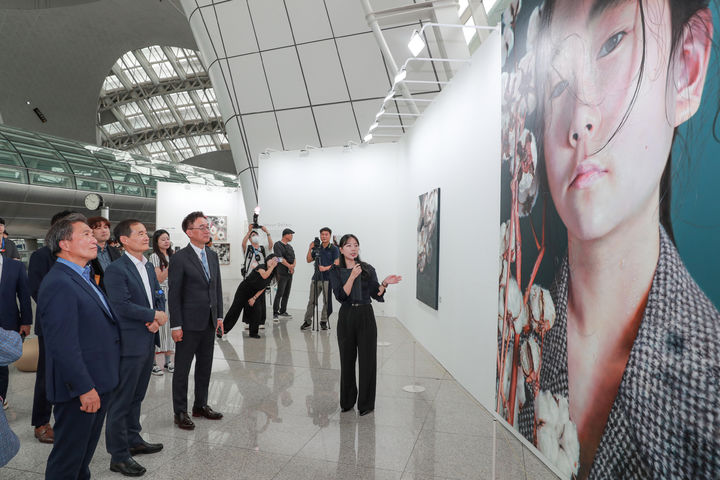 [서울=뉴시스] 지난 26일 인천공항 제1교통센터에서 열린 ‘2043 Kiaf 인천공항 특별전 개막식’에서 인천국제공항공사 이학재(왼쪽 첫 번째)사장을 포함한 관계자들이 서우련 도슨트(오른쪽 첫 번째)의 설명을 들으며 작품을 감상하고 있다. 2024.08.27. (사진=인천공항공사 제공) photo@newsis.com *재판매 및 DB 금지