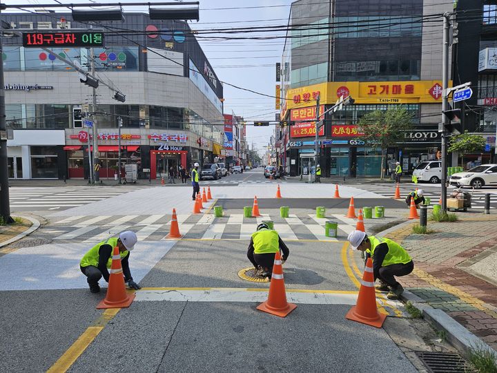 [천안=뉴시스] 천안시 서북구 건설과가 지난 25일 두정동 먹자골목 입구 교차로에 아스팔트 차열도색을 시공하고 있다. 2024.8.27 photo@newsis.com *재판매 및 DB 금지