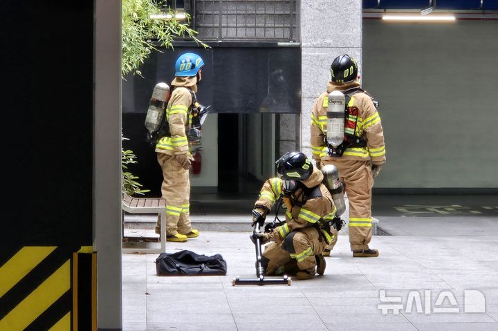 [부산=뉴시스] 김민지 기자 = 27일 오전 부산 부산진구의 한 아파트 지하 주차장에서 전기차 화재 상황을 가정한 소방 대응 합동 훈련이 진행되고 있다. 소방은 전기차 화재 진압 장비인 상방형 관창을 연결하고 있다. 2024.08.27. mingya@newsis.com