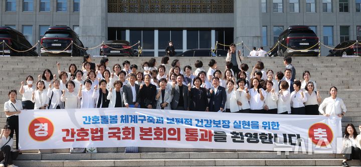 [서울=뉴시스] 조성봉 기자 = 지난달 28일 오후 서울 여의도 국회에서 열린 제417회국회(임시회) 제2차 본회의에서 간호법안(대안)이 재적300인 중 재석 290인, 찬성 283인, 반대 2인, 기권 5인으로 통과된 가운데 대한간호협회 소속 간호사들과 박주민 보건복지위원장을 비롯한 의원들이  본청 계단에서 기념촬영을 하고 있다. 2024.08.28. suncho21@newsis.com