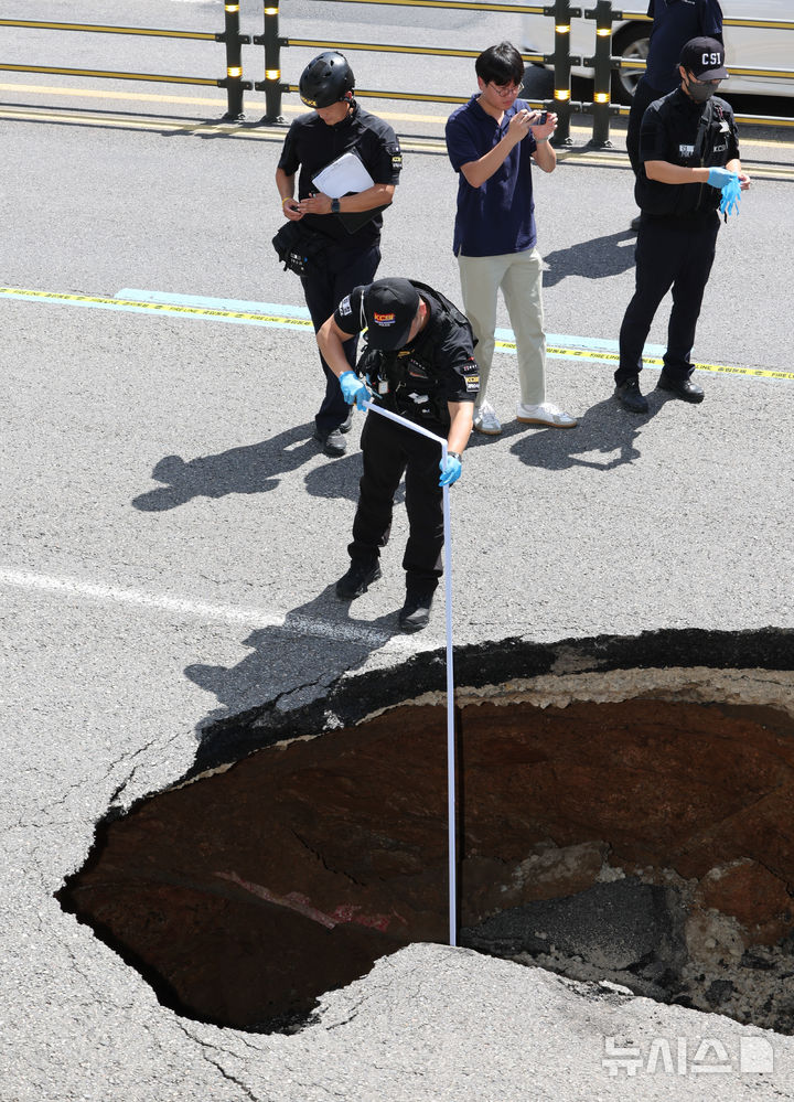 [서울=뉴시스] 황준선 기자 = 29일 서울 서대문구 성산로에 땅꺼짐 사고가 발생해 과학수사대원들이 사고 현장을 조사하고 있다. 2024.08.29 hwang@newsis.com