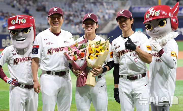 [서울=뉴시스] 추상철 기자 = 키움 김혜성이 29일 오후 서울 구로구 고척스카이돔에서 2024 KBO리그 삼성 라이온즈와 키움 히어로즈 경기 시작전 열린 '1000안타 달성 기념 시상식'에서 홍원기 감독, 송성문으로 부터 꽃다발을 전달 받은 후 기념촬영을 하고 있다. 2024.08.29. scchoo@newsis.com