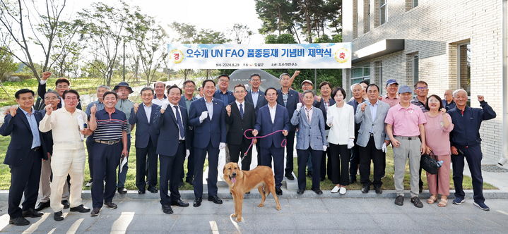 사람 살린 의견 '오수개'의 UN 식량농업기구(FAO) 품종 등재를 기념하는 임실군의 기념비 제막식에서 복원·육종된 오수개와 함께 심민 군수를 비롯한 관계자들이 기념사진을 찍고 있다. *재판매 및 DB 금지