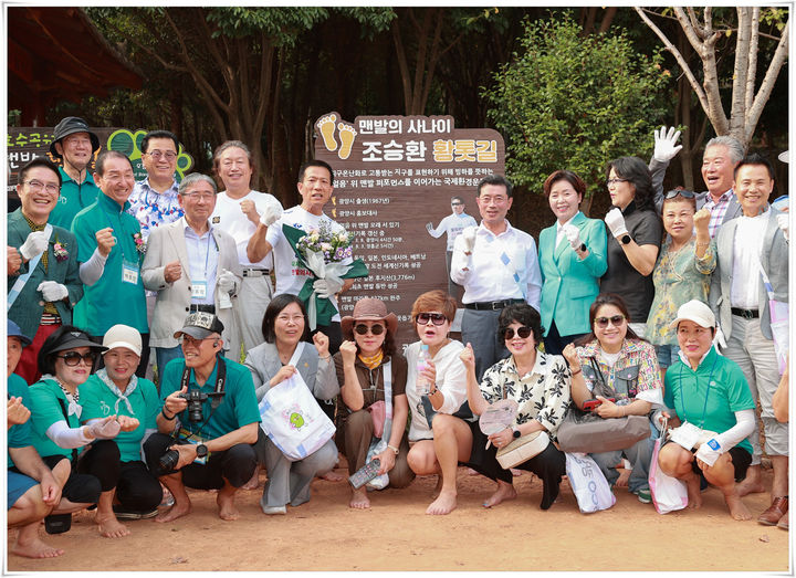 [광양=뉴시스] 광양시가 조성한 조승환 맨발 황톳길 안내판 앞에서 황톳길 개장식 참석자들이 기념촬영 하고 있다. (사진=광양시 제공) 2024.09.03. photo@newsis.com *재판매 및 DB 금지