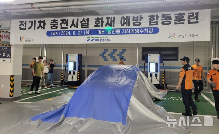 [광명=뉴시스] 광명시와 광명도시공사, 광명소방서가 지난달 27일 철산동 지하공영주차장에서 질식소화포를 사용한 전기차 충전시설 화재예방 합동훈련을 벌였다.(사진=광명시 제공)2024.09.03.photo@newsis.com