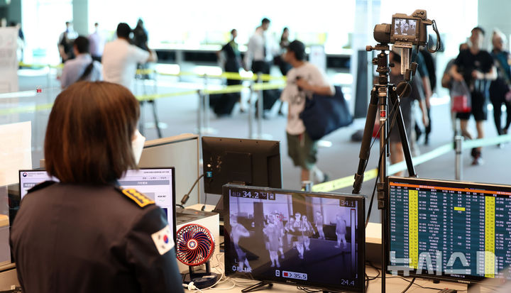 [인천공항=뉴시스] 김선웅 기자 = 국립인천공항검역소 관계자가 입국자들을 대상으로 카메라를 통해 발열 상태를 확인하고 있다. 2024.09.03. mangusta@newsis.com