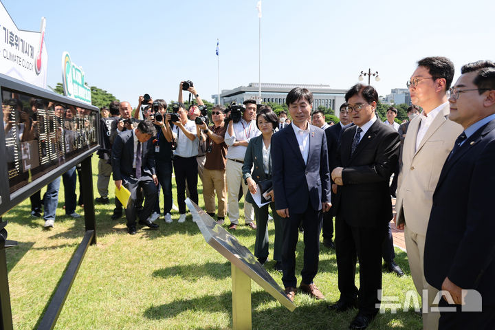 [서울=뉴시스] 조성우 기자 = 4일 오전 서울 여의도 국회 본청 앞 잔디밭에서 열린 기후위기시계 이전 제막식에서 우원식(오른쪽 세 번째) 국회의장과 박찬대(오른쪽) 더불어민주당 원내대표 등 참석자들이 기후위기 시계를 살펴보고 있다. 2024.09.04. xconfind@newsis.com